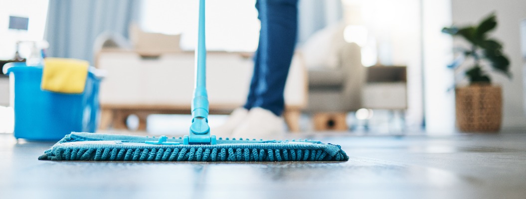 Hauswirtschaft, Reinigung und Hausmädchen mit einem Mopp, um den Boden im Wohnzimmer eines Hauses zu reinigen. Weibliche Hausangestellte, Putzfrau und Hausfrau, die den Boden in ihrem Haus von Bakterien, Staub und Schmutz befreit.